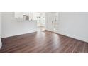 Open living space with hardwood floors, white walls, and a view into the kitchen at 3855 Canyon Ranch Rd # 104, Highlands Ranch, CO 80126