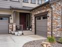 Close-up of the front entrance with a stone garage and cozy porch at 3187 S Quaker St, Morrison, CO 80465