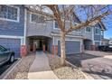 View of the front townhome exterior with brick posts along the driveway at 1303 S Danube Way # 104, Aurora, CO 80017