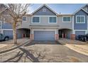 Exterior front view of townhome with grey and blue tones and two-car garage at 1303 S Danube Way # 104, Aurora, CO 80017