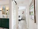 Hallway leading to bedroom and bathroom with stylish sliding door and decor at 2482 Otis Ct, Edgewater, CO 80214