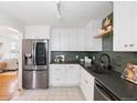 Stylish kitchen features stainless steel appliances, white cabinets and modern countertops at 2482 Otis Ct, Edgewater, CO 80214
