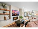 Open-concept living room featuring a fireplace, decorative shelves, and lots of natural light at 1415 Irving St, Denver, CO 80204