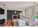 A cozy living room featuring a fireplace, hardwood floors, and a comfortable white sofa at 6057 S Pierson St, Littleton, CO 80127