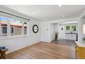 Bright living room featuring hardwood floors, white walls, and an open layout leading into the modern kitchen at 1852 S Decatur St, Denver, CO 80219