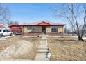 Charming brick home with a well-kept lawn and inviting front entrance at 7634 Navajo St, Denver, CO 80221