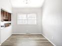 Bright dining area with modern lighting and wood-look flooring, next to kitchen at 6156 W Jefferson Ave, Denver, CO 80235