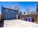 Large detached garage with a wide concrete driveway for ample parking in a fenced backyard at 1545 N Harrison St, Denver, CO 80206