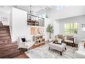 Bright living room features high ceilings, modern furnishings, and a staircase at 18213 E Saskatoon Pl, Parker, CO 80134