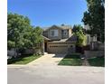 Well-maintained two-story home with a two-car garage, inviting porch, and lush green lawn at 10249 Trailriders Dr, Littleton, CO 80125