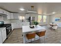 This bright, modern kitchen features white cabinets, an island, and stainless steel appliances at 9036 Mandel St, Denver, CO 80260
