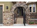 Inviting entryway featuring a stone archway and decorative gate, adding character and charm to the home at 7178 Galaxy Ct, Castle Rock, CO 80108