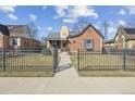 Inviting brick home featuring a fenced front yard and a sidewalk leading to the entrance at 1355 Hudson St, Denver, CO 80220