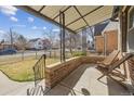 Cozy covered front porch with brick accents, offering an inviting outdoor seating area at 1355 Hudson St, Denver, CO 80220