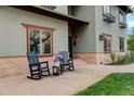 Inviting front porch with comfortable rocking chairs and charming flower arrangement at 2931 S Cook St, Denver, CO 80210
