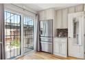 Bright kitchen with stainless steel refrigerator, outdoor access, and stone countertops at 6400 E Mississippi Ave, Denver, CO 80224