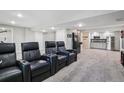 Finished basement with theater seating, wet bar, and carpeted floors at 775 Poppywood Dr, Highlands Ranch, CO 80126
