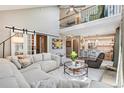 Open-concept living room boasts high ceilings, modern furniture, and seamless flow to the kitchen at 775 Poppywood Dr, Highlands Ranch, CO 80126