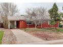 Traditional single-story red brick home featuring mature trees and a covered car port at 2885 S Gilpin St, Denver, CO 80210