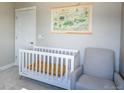 Cozy Bedroom features a crib, glider, soft paint, and custom map art at 10018 E 62Nd Ave, Denver, CO 80238