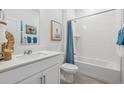 Bright bathroom with a combined tub and shower, white vanity, and tasteful decorative artwork at 4708 Windmill Dr, Brighton, CO 80601