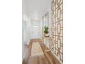 Bright entryway featuring wood floors, decorative wall art, and a stylish console table with a lush green plant at 4708 Windmill Dr, Brighton, CO 80601