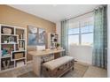 Sunlit office space with a large window, a modern desk, and built-in shelves for organized storage at 4708 Windmill Dr, Brighton, CO 80601