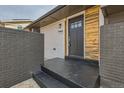 Charming front entryway featuring a black front door and brick accents at 12932 E Elgin Pl, Denver, CO 80239