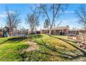 Expansive backyard featuring a lush lawn, mature trees, and recreational amenities at 3395 W Union Ave, Englewood, CO 80110