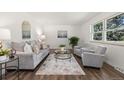 Bright living room featuring hardwood floors, plush seating, and natural light from a large window at 5193 Zinnia St, Arvada, CO 80002