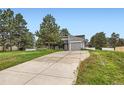 Charming home with a long driveway, mature trees, and attached garage at 679 S Pearl St, Elizabeth, CO 80107