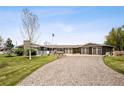 Charming exterior featuring brick accents, a well manicured lawn and a three-car garage at 12941 W 75Th Ave, Arvada, CO 80005