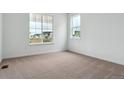 Bright, carpeted bedroom with two windows providing ample natural light at 39181 Anthony St, Elizabeth, CO 80107