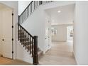 Bright entryway with hardwood floors leads to a staircase with dark wood banister and white risers at 39181 Anthony St, Elizabeth, CO 80107