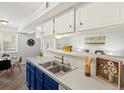 Kitchen area featuring stainless steel sink, blue cabinets, and eat-in dining at 7700 W Glasgow Place # 15A, Littleton, CO 80128