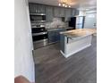 A modern kitchen featuring gray cabinets, stainless appliances and a granite island at 4665 W 6Th Ave # 21, Denver, CO 80204
