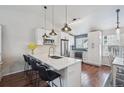 Bright kitchen features white cabinets, quartz countertops, stainless appliances, and bar stool seating at 11072 Quail Ct, Parker, CO 80134