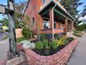 Landscaped front yard with brick retaining wall, lush plantings, and partial view of the brick home at 300 S Lincoln St, Denver, CO 80209