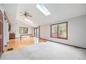 Open living room with hardwood floors, skylights, ceiling fan, and natural light at 10858 Norton Ave, Conifer, CO 80433