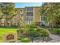 Well maintained building with a manicured lawn, lush greenery, and inviting bench seating near the building entrance at 3022 S Wheeling Way # 205, Aurora, CO 80014