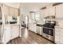 Charming kitchen with white cabinets, stainless steel appliances, and wood flooring at 846 S Sheridan Blvd, Denver, CO 80226