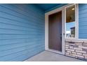 The front door entrance features stone accents, modern blue siding, and a secure, stylish entryway at 6882 Oak Canyon Cir, Castle Pines, CO 80108