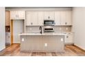 Bright kitchen boasts an island, stainless steel appliances, and elegant white cabinetry at 6882 Oak Canyon Cir, Castle Pines, CO 80108