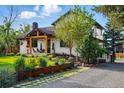 Well-manicured front yard featuring a charming white home with black trim and a rustic wooden porch at 1801 Redwood Ave, Boulder, CO 80304