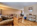 Comfortable living room with hardwood floors, furniture set, and a view of the dining room beyond at 3035 S Biscay St, Aurora, CO 80013