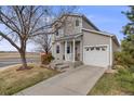 Charming two-story home with a well-maintained lawn, a single-car garage, and inviting front porch at 1495 Hummingbird Cir, Brighton, CO 80601