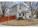 Charming two-story home with a well-maintained lawn, a single-car garage, and blooming trees at 1495 Hummingbird Cir, Brighton, CO 80601