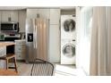 Kitchen with stainless steel refrigerator, grey cabinets, and laundry area near the window at 1024 Stuart St, Denver, CO 80204