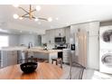 Open concept kitchen with stainless steel appliances, grey cabinets, butcher block island, and modern lighting at 1024 Stuart St, Denver, CO 80204