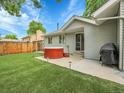 Backyard featuring a well-kept lawn, mature trees, a large patio, a hot tub, and a barbecue at 9423 Brentwood St, Broomfield, CO 80021